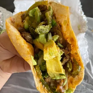 a hand holding a taco