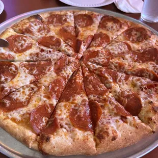 a pepperoni pizza on a pizza pan