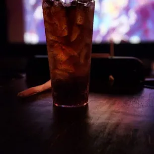 a glass of soda with ice and a straw