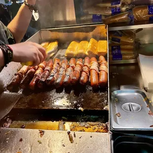 a man cooking hot dogs