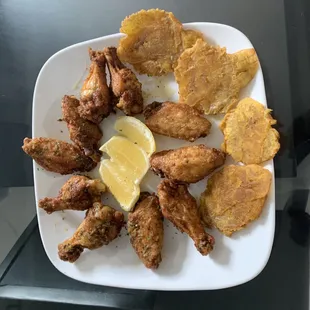 a plate of fried chicken wings and chips