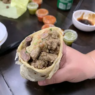 a hand holding a burrito