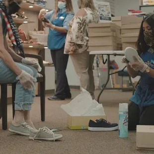 Helping customers try on shoes at Alan's Shoes Speedway