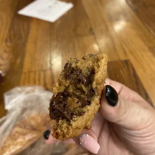 a hand holding a half eaten cookie