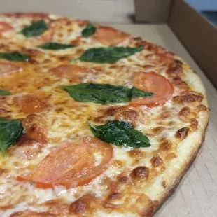 The Margherita Pizza - a taste of Italy's rich culinary heritage! Includes Fresh tomatoes, fragrant basil leaves, parmesan, and Olive oil.