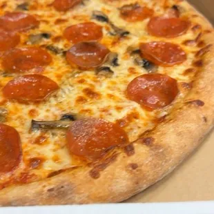 A pizza made with pepperoni and mushrooms.