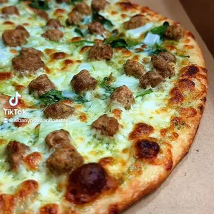 Our specialty Green Pizza with Italian sausage as an additional topping.