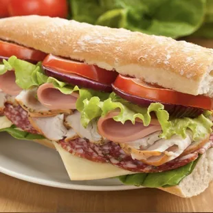a sub sandwich with meat, lettuce, tomato, and cheese