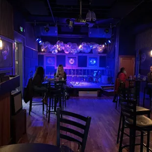 a stage with people sitting at tables