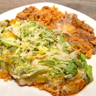 Chicken Enchilada (2) Plate. Topped with lettuce &amp; cheese. Comes with delicious refried beans &amp; fluffy rice. Love this dish!