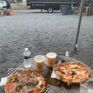 two pizzas on a picnic table