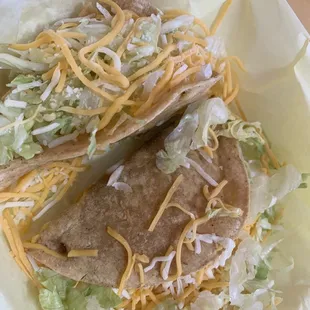 a taco with cheese and lettuce
