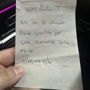 a hand holding a note in a car