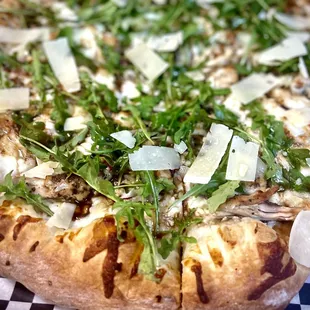 a pizza topped with greens and cheese