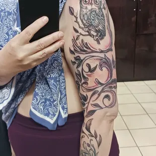 Halloween Tat: detailed owl with intense eyes atop curving branches and leaves