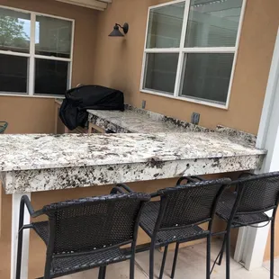 a kitchen counter and chairs