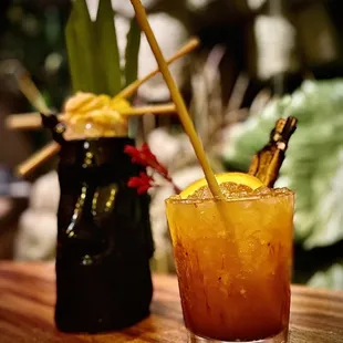 a glass of orange juice with a straw