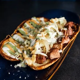 French bread sandwich (steak, chicken or steak and chicken, provolone cheese, caramelized onions, 3 sauces and French potatoes fries on top)