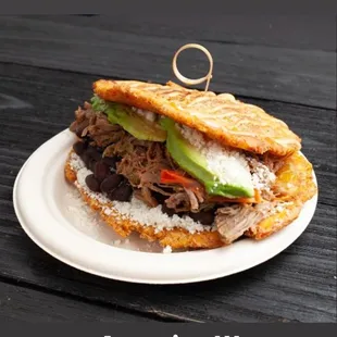 Plantain sandwich "patacón Venezuela" (white cheese, black beans, shredded beef and avocado)