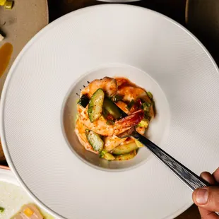 a person holding a fork over a plate of food