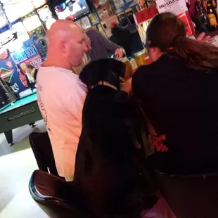 Well behaved popcorn eating black lab belly up at bar! More manners than half the customers!