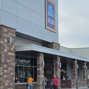 people walking in front of a aldi store