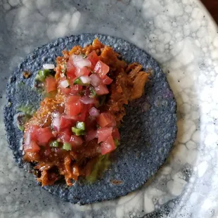 a blue tortilla topped with salsa