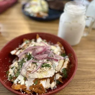 Alebrijes chilaquiles salsa roja, shredded chicken and eggs