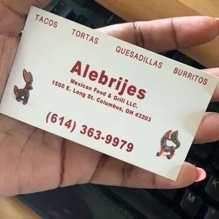 a hand holding a business card