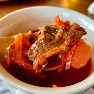 a bowl of stew with a wooden spoon