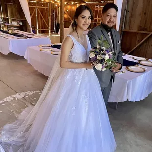 Bride and father preparing to exit barn for ceremony