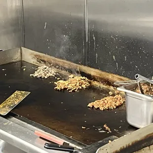 Freshly cooked meat on the grill, two of those piles are a single taco