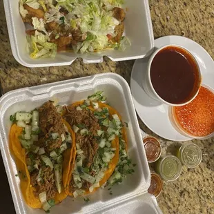 a plate of tacos and a cup of sauce