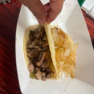 a hand holding a taco