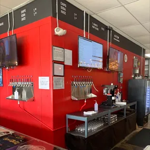 a red wall with beer taps