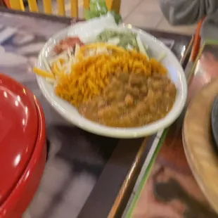 a plate of chili, beans, and fries