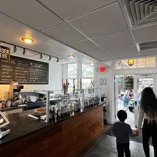 a woman and a child standing in front of the counter
