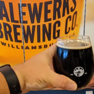 a hand holding a glass of beer
