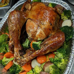 a roasting turkey with broccoli and carrots