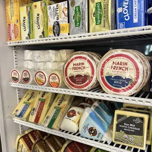 a variety of cheeses in a refrigerator