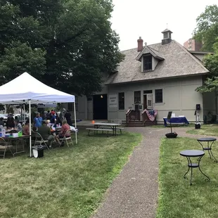 Outside on the lawn, looking at the carriage house and museum shop.