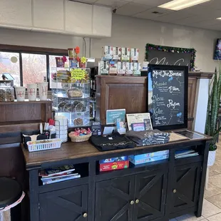 a coffee shop counter with a chalkboard sign