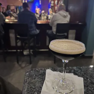 a cocktail in a martini glass on a table