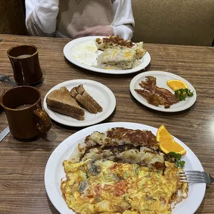 a man sitting at a table with plates of food