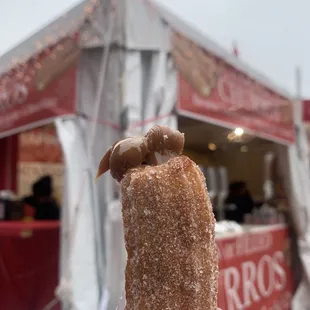 a hand holding a sugared donut