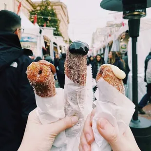 two people holding doughnuts