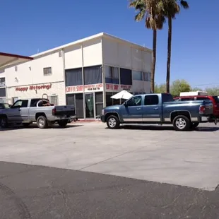 two trucks parked in front of a coffee shop