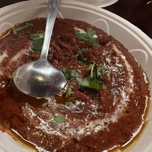 a bowl of stew with a spoon in it