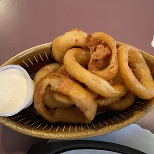 onion rings in a bowl with dipping sauce