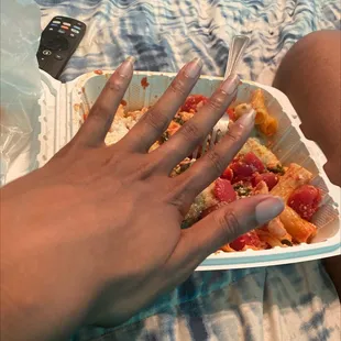 a woman's hand holding a slice of pizza